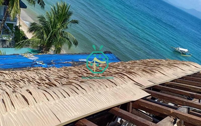 Install the HDPE palm thatch panels on the tiki hut guest room roofing on beach hotel in tropical countries